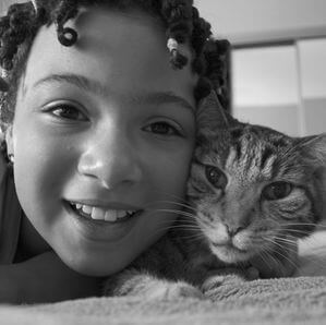 young girl and cat looking into camera